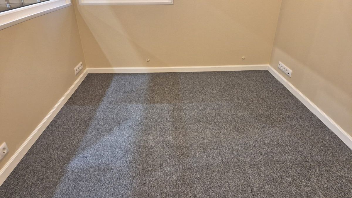 Gaišas sienas, paklājs un rozetes biroja telpā