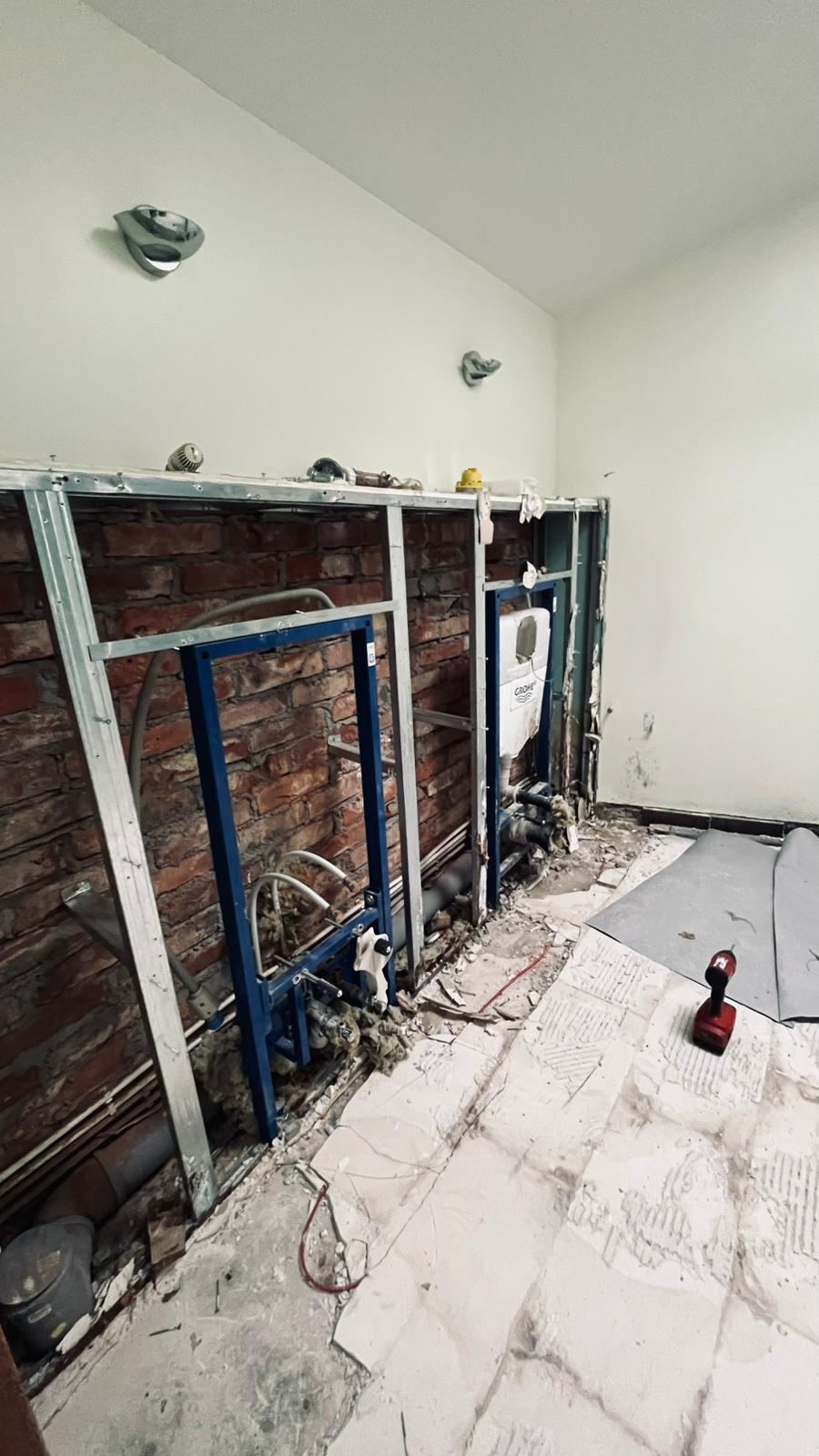 Vannas istaba pirms remonta: ķieģeļu siena ar divām vecām tualetes instalācijām